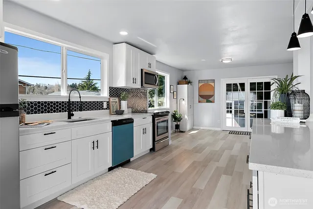 a kitchen with granite countertop a sink stainless steel appliances and cabinets