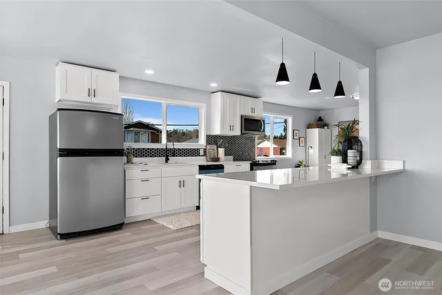 a kitchen with white cabinets and stainless steel appliances