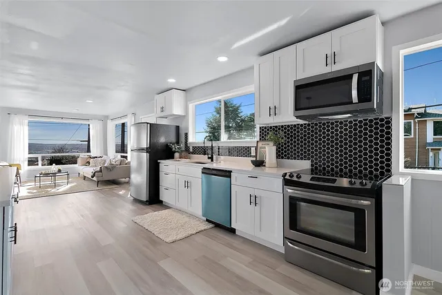 a kitchen with stainless steel appliances a stove a sink and a microwave