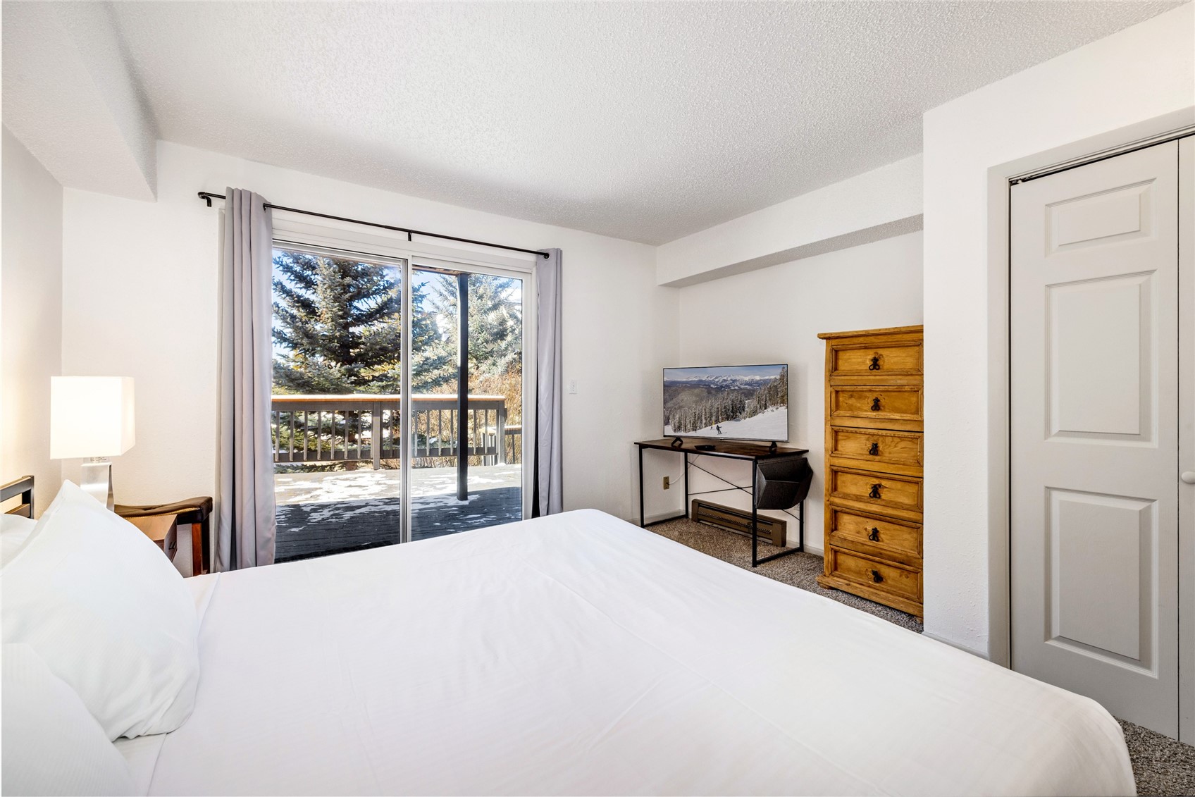 1473 East Keystone Road, Unit 2928 Keystone, CO 80435 - Photo 7 of 30 Bedroom featuring access to exterior, carpet floors, and a textured ceiling