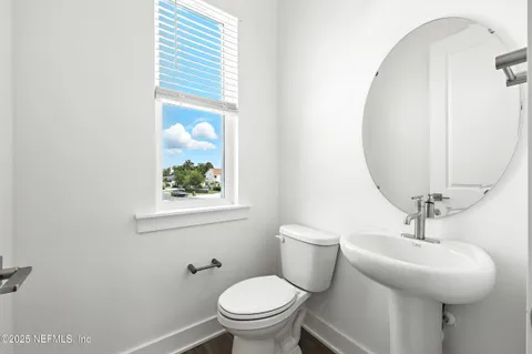 a bathroom with a toilet sink and mirror