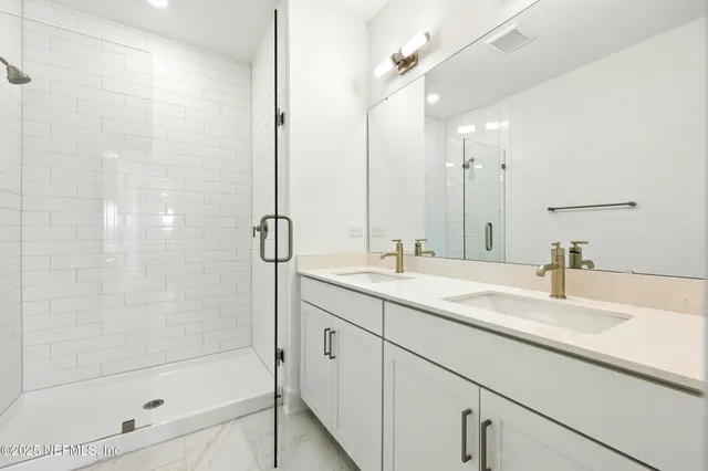a bathroom with a bathtub shower sink vanity and mirror