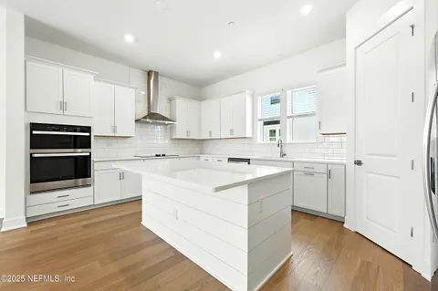 a kitchen with a white cabinets and wooden floor