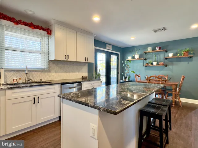 a kitchen with stainless steel appliances granite countertop a sink a stove and a wooden cabinets