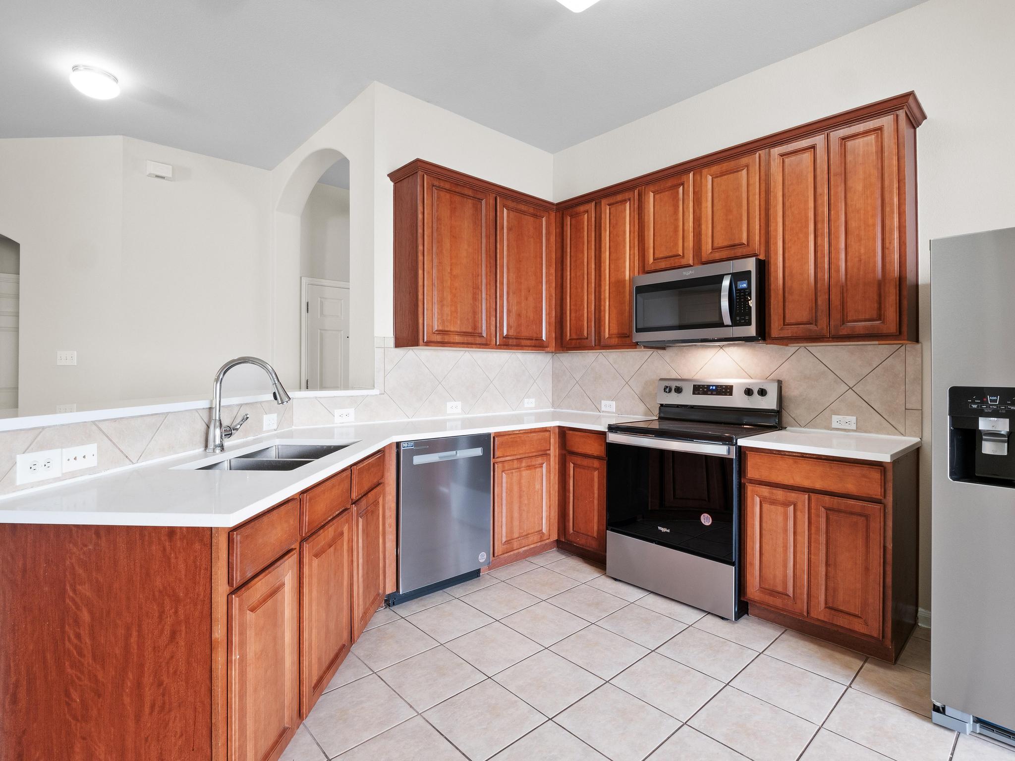 429 Falcon Lane Leander, TX 78641 - Photo 11 of 27 a kitchen with stainless steel appliances granite countertop a sink stove and microwave