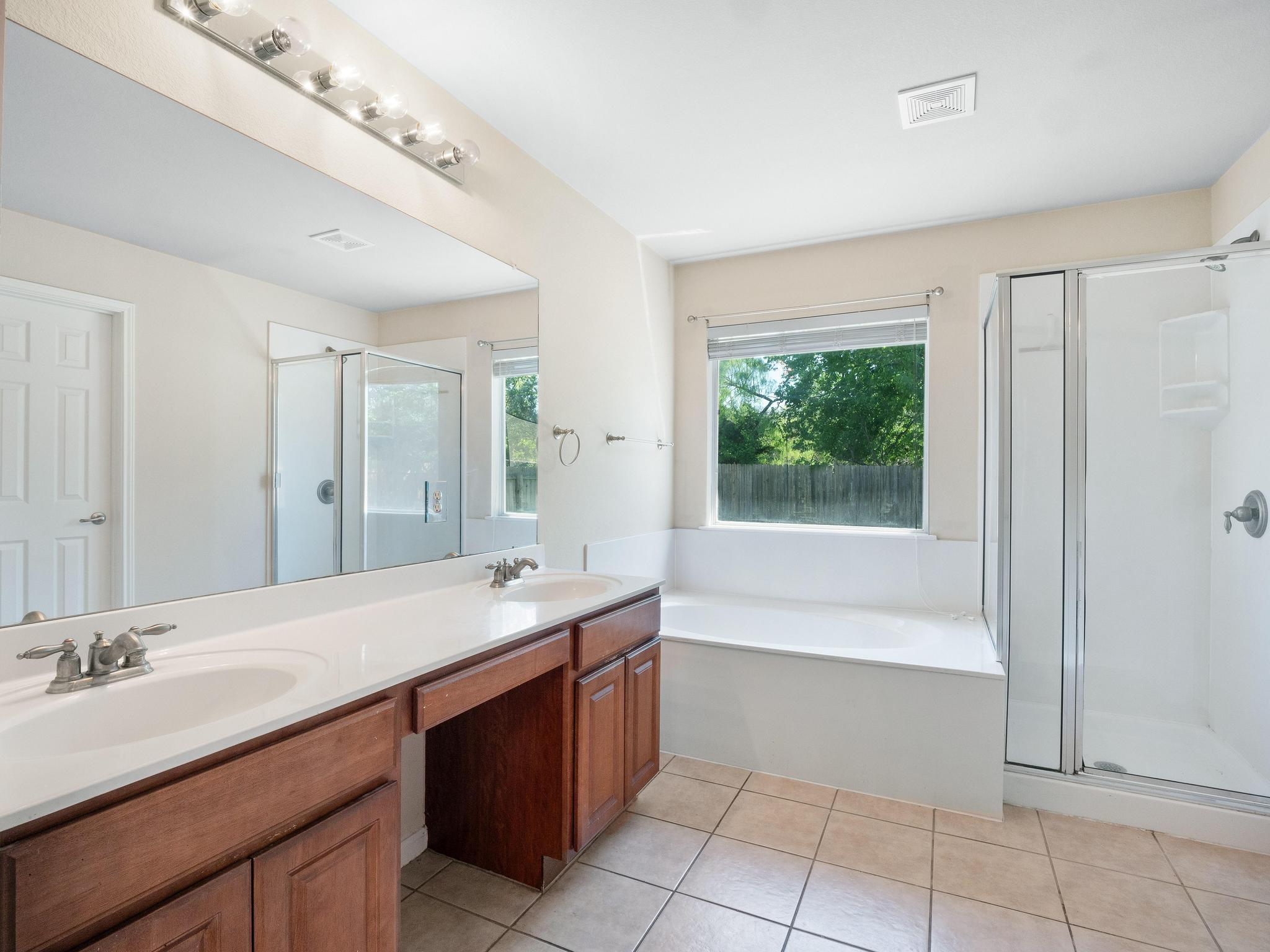 429 Falcon Lane Leander, TX 78641 - Photo 16 of 27 a bathroom with a tub sink and mirror