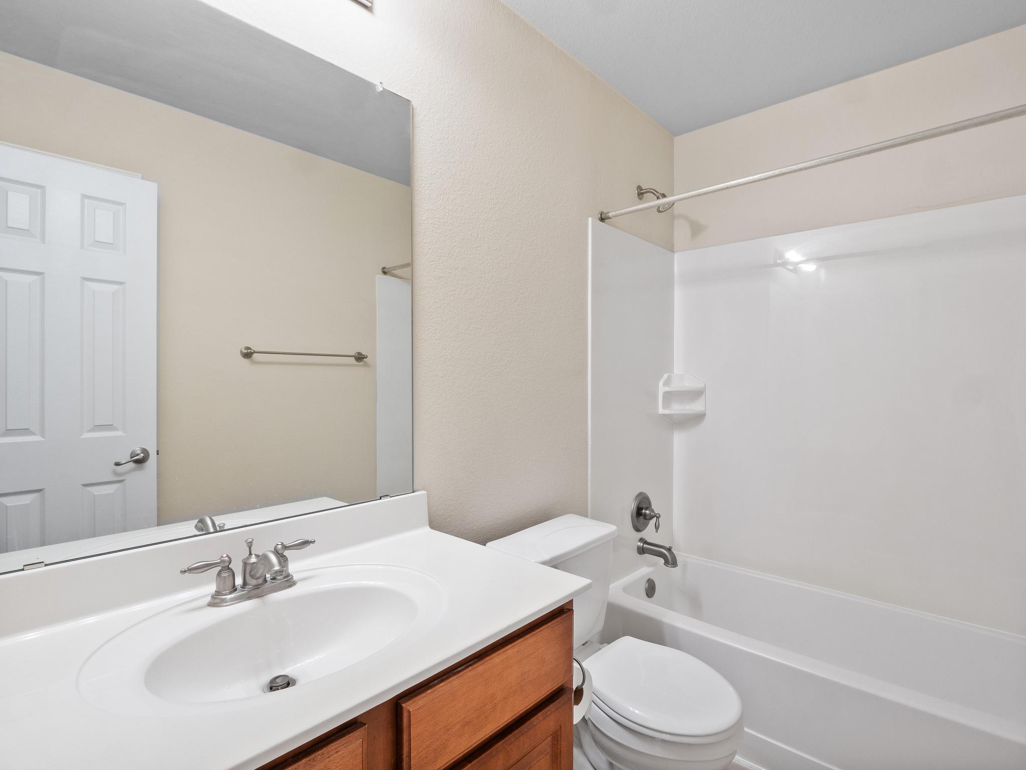 429 Falcon Lane Leander, TX 78641 - Photo 22 of 27 a bathroom with a sink a toilet a mirror and shower