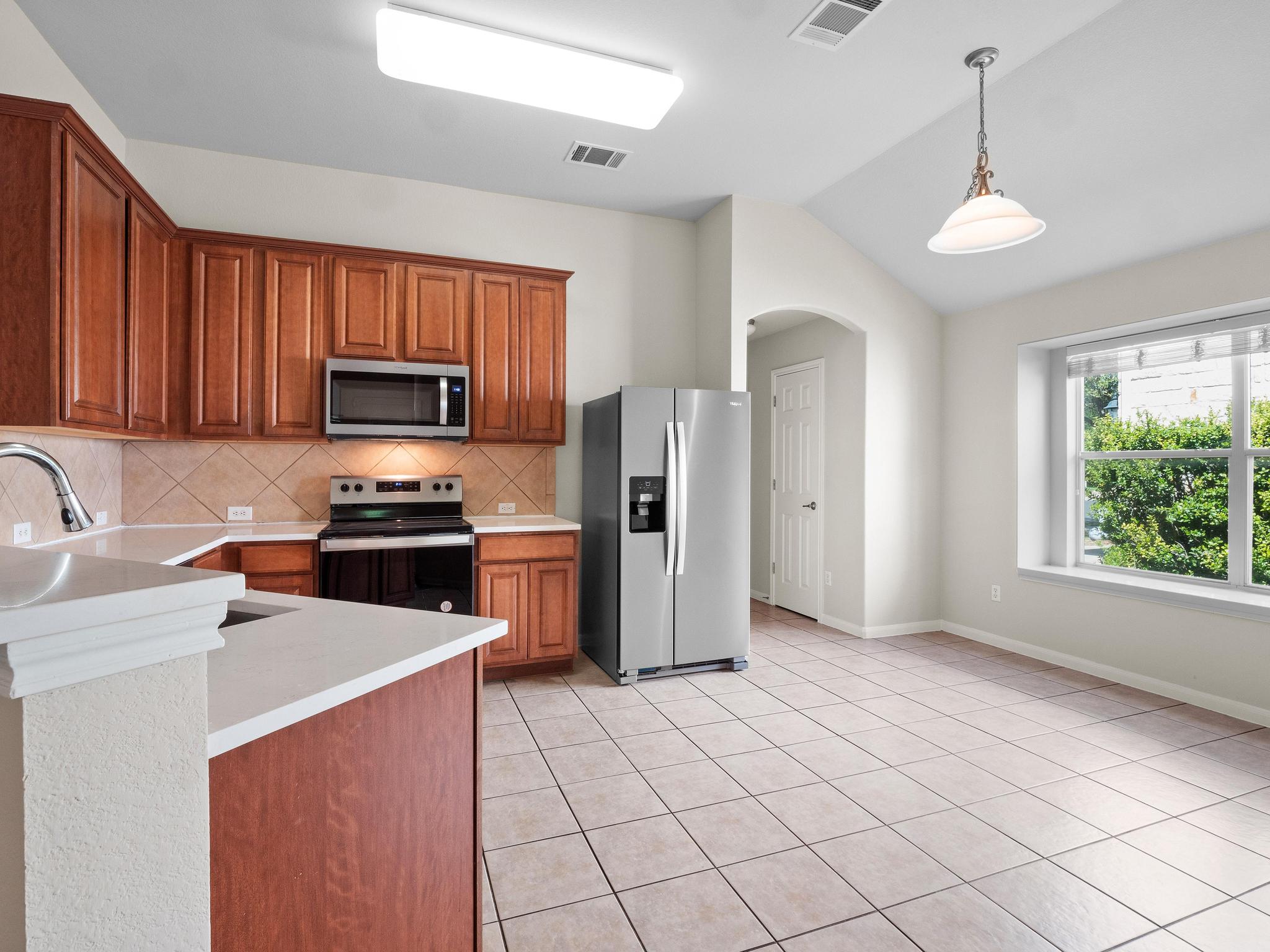 429 Falcon Lane Leander, TX 78641 - Photo 9 of 27 a kitchen with stainless steel appliances a refrigerator sink and cabinets