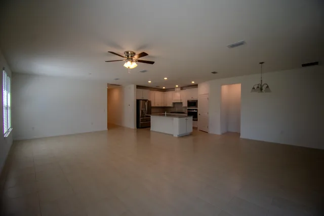 a view of an empty room with a kitchen