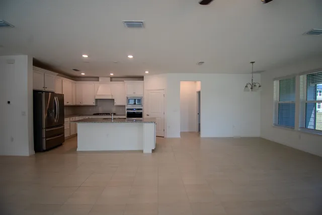 a kitchen with stainless steel appliances kitchen island granite countertop a refrigerator and a stove top oven