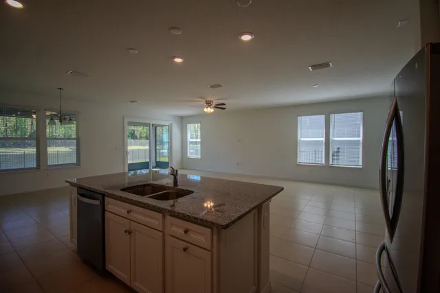 a kitchen with granite countertop a sink and dishwasher with wooden floor