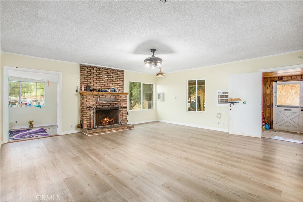 23255 Warren Road San Jacinto, CA 92582 - Photo 30 of 56 wooden floor fireplace and windows in an empty room