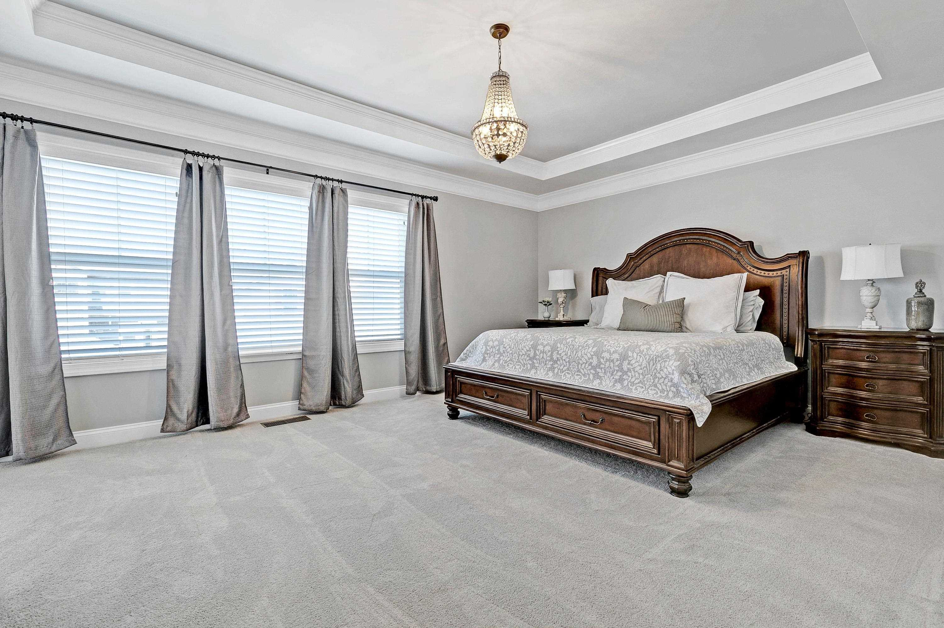 1529 Fullerton Place Raleigh, NC 27607 - Photo 26 of 53 a bedroom with a large bed and a chandelier