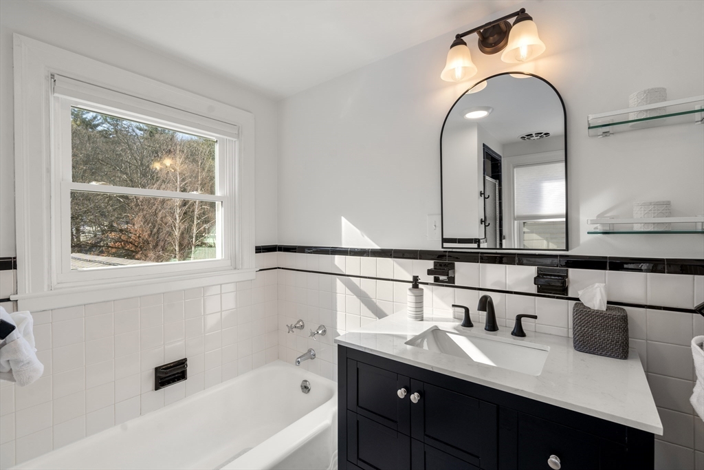 48 Spring Street Wakefield, MA 01880 - Photo 20 of 28 a bathroom with a tub a sink and mirror