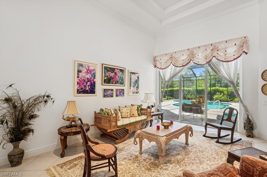 7488 Treeline Drive Naples, FL 34119 - Photo 12 of 22 Living area featuring ornamental molding, a towering ceiling, and tile patterned flooring