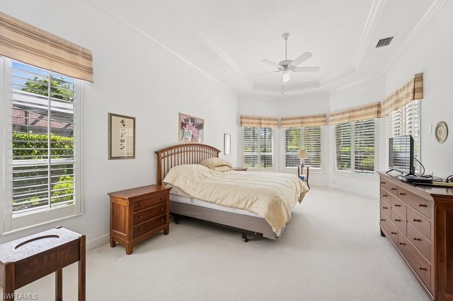 7488 Treeline Drive Naples, FL 34119 - Photo 14 of 22 Bedroom featuring light colored carpet, crown molding, a tray ceiling, and a ceiling fan