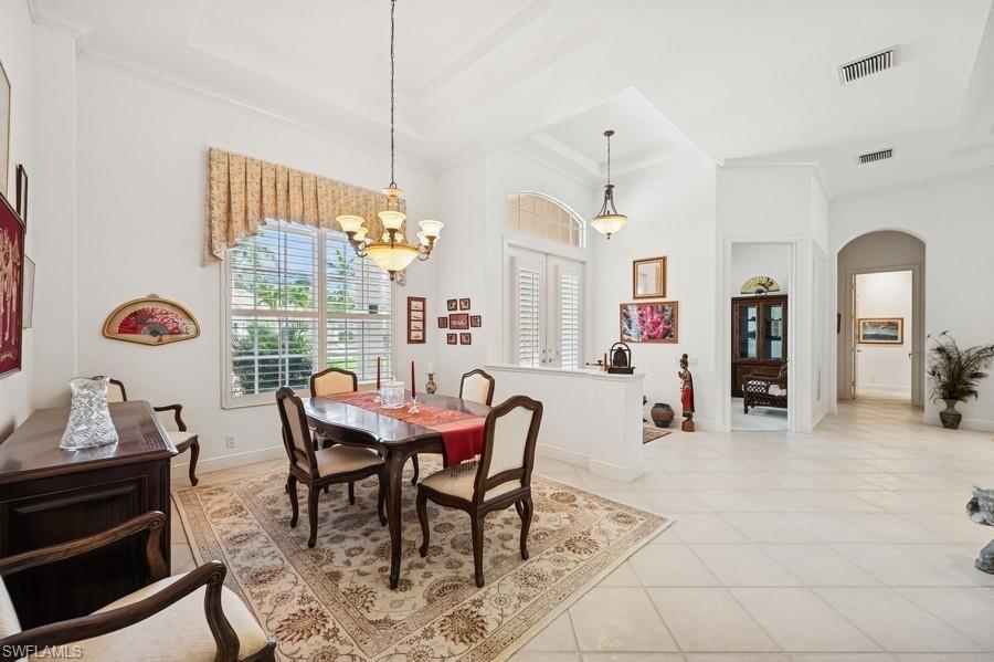 7488 Treeline Drive Naples, FL 34119 - Photo 6 of 22 Dining space featuring arched walkways, a chandelier, light tile patterned floors, and crown molding