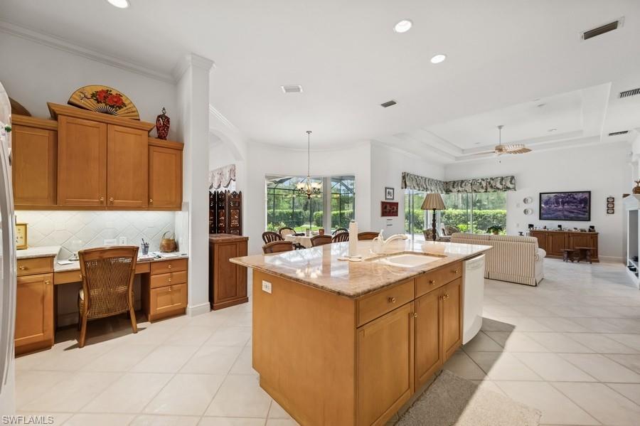 7488 Treeline Drive Naples, FL 34119 - Photo 22 of 22 Kitchen with crown molding, tasteful backsplash, dishwasher, open floor plan, and light stone counters