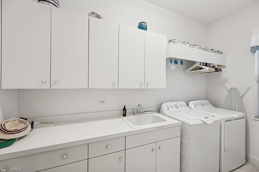 7488 Treeline Drive Naples, FL 34119 - Photo 9 of 22 Washroom featuring cabinet space and washer and clothes dryer
