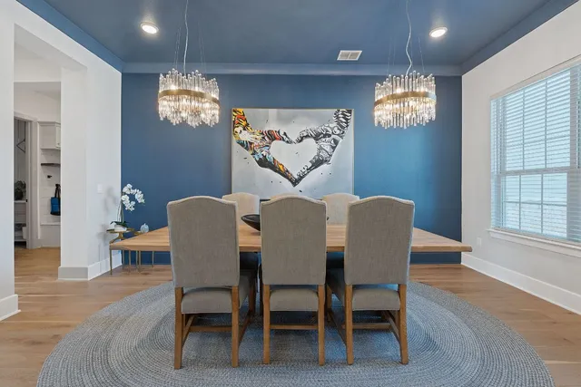 a view of a dining room with furniture a chandelier and wooden floor