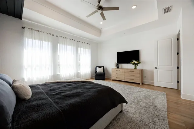 a bedroom with a bed tv and a window