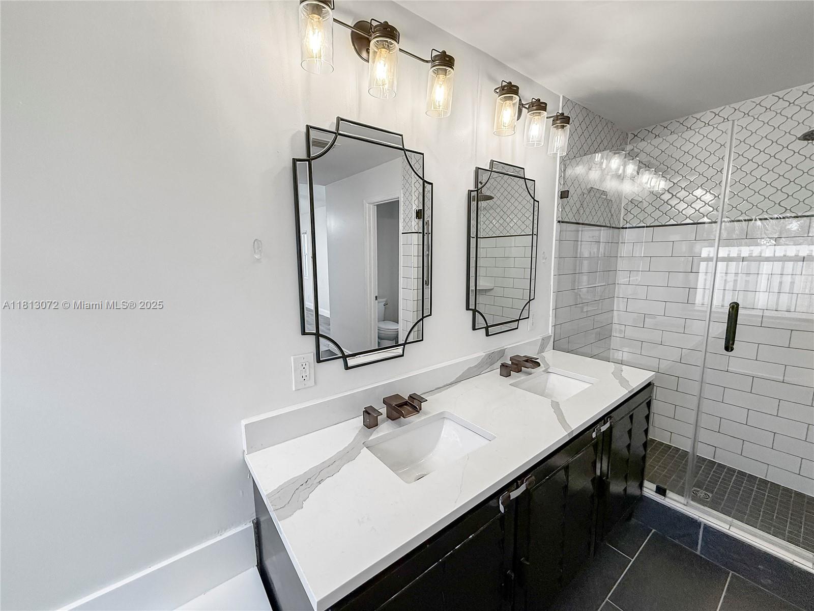 841 Stanton Drive Weston, FL 33326 - Photo 16 of 25 a bathroom with a sink a mirror and shower