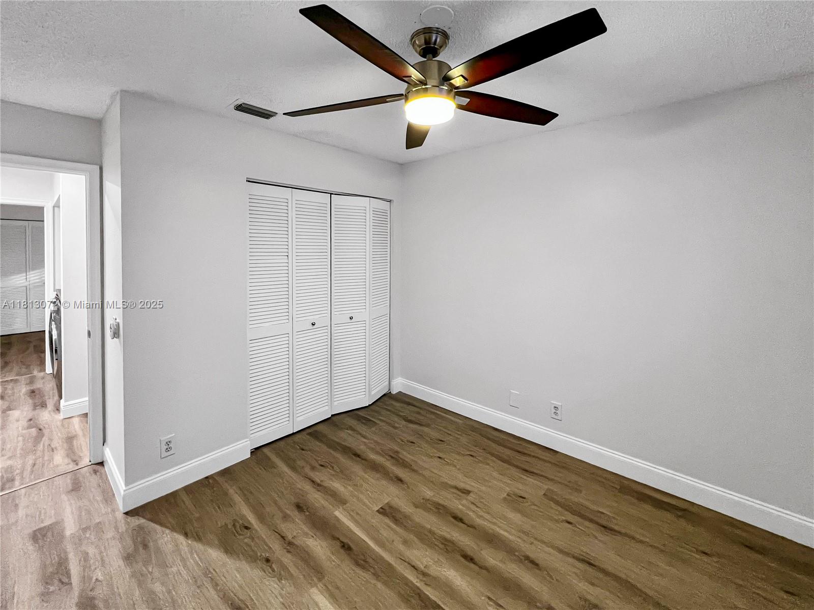 841 Stanton Drive Weston, FL 33326 - Photo 20 of 25 an empty room with wooden floor and fan