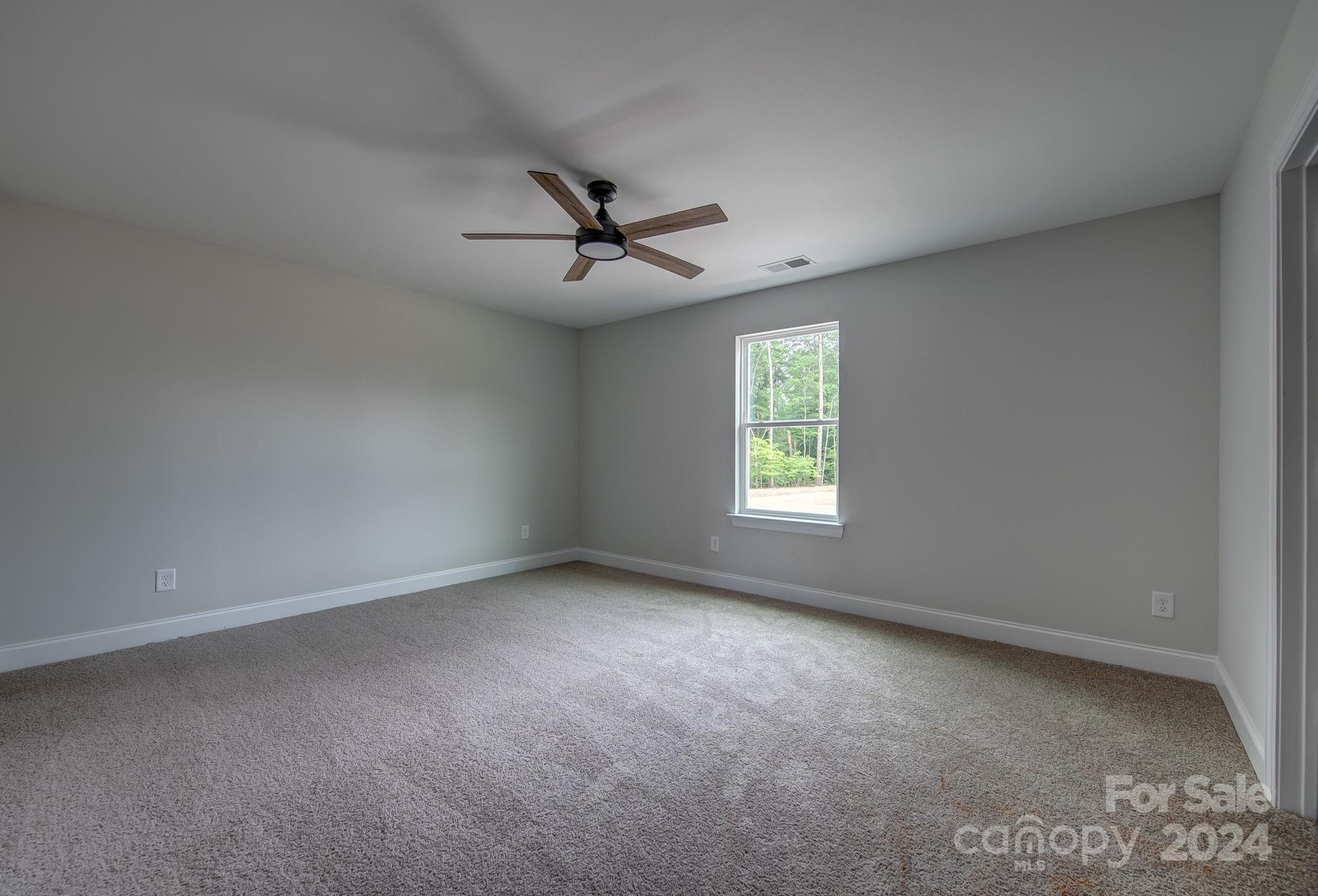527 Blacksnake Road Stanley, NC 28164 - Photo 14 of 22 an empty room with a window and a ceiling fan