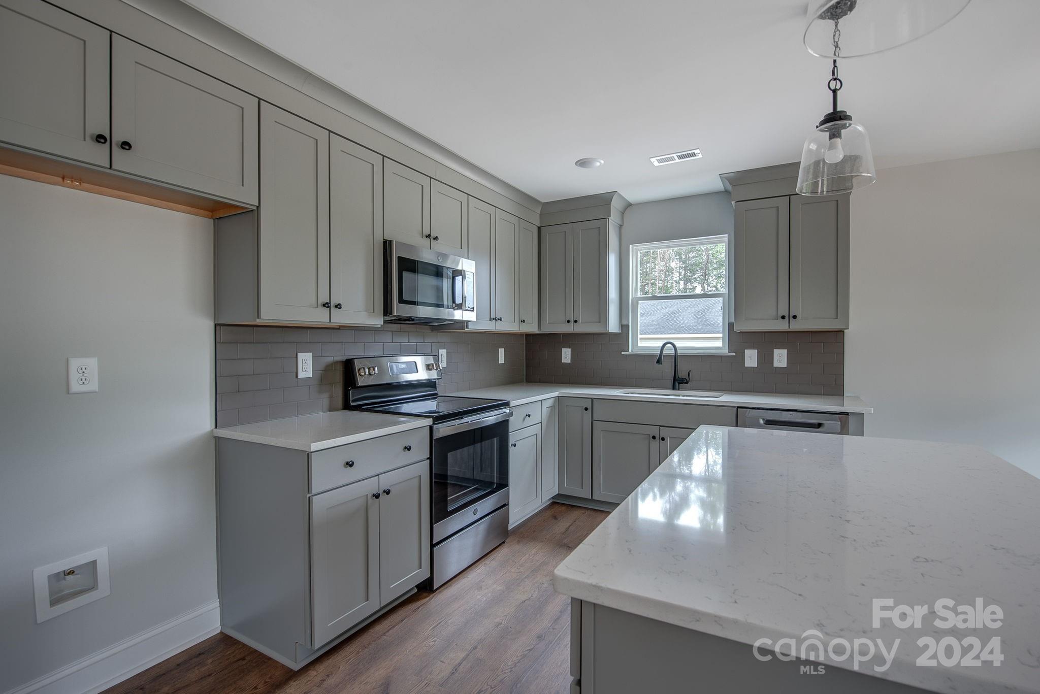 527 Blacksnake Road Stanley, NC 28164 - Photo 9 of 22 a kitchen with stainless steel appliances granite countertop a sink a stove and a refrigerator