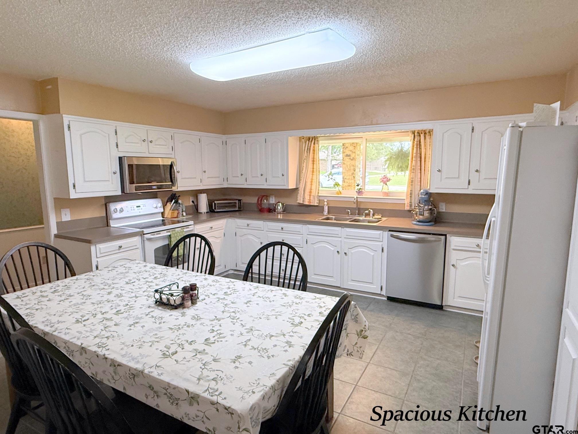 237 Oregon Street Van, TX 75790 - Photo 7 of 44 a kitchen with granite countertop a sink a stove a counter space and cabinets