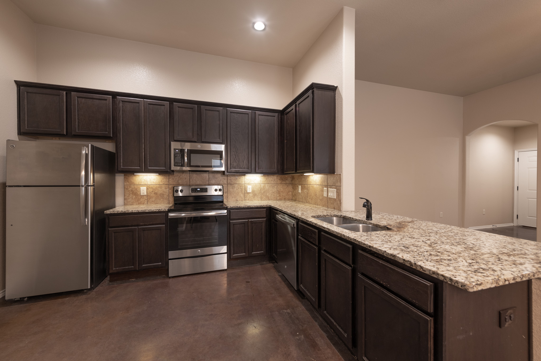 448 Jack Rabbit Lane, Unit A Buda, TX 78610 - Photo 7 of 19 a kitchen with stainless steel appliances granite countertop a refrigerator a stove a sink and a microwave