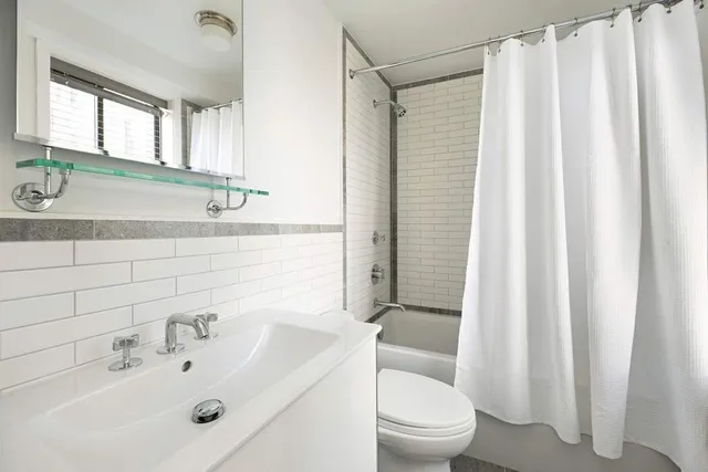 a bathroom with a sink a toilet and shower curtain