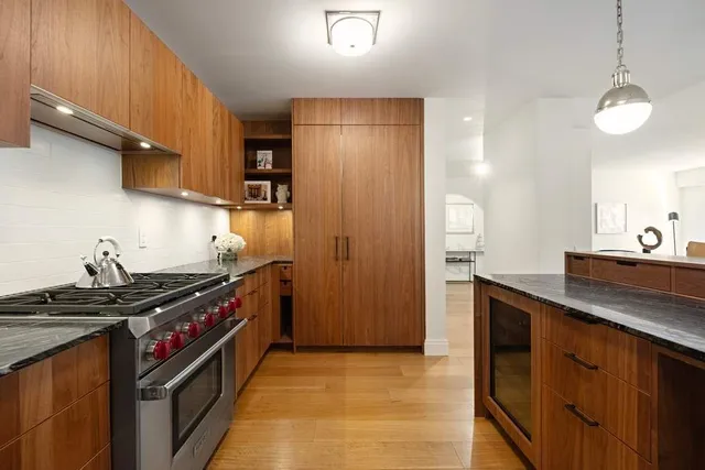 a kitchen with stainless steel appliances granite countertop a stove a sink and a refrigerator