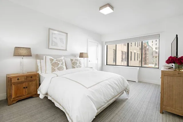 a bedroom with a bed and a tv on the dresser