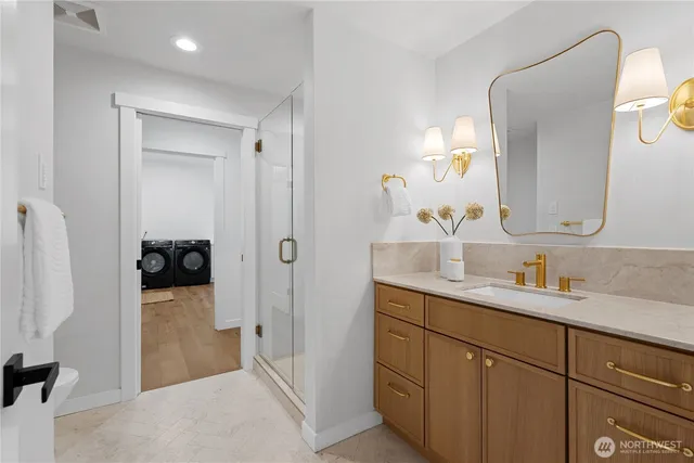 a en suite bathroom with a granite countertop sink and a mirror