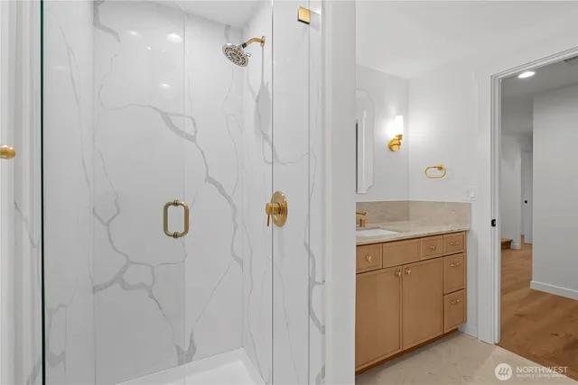 a bathroom with a granite countertop sink a mirror and shower