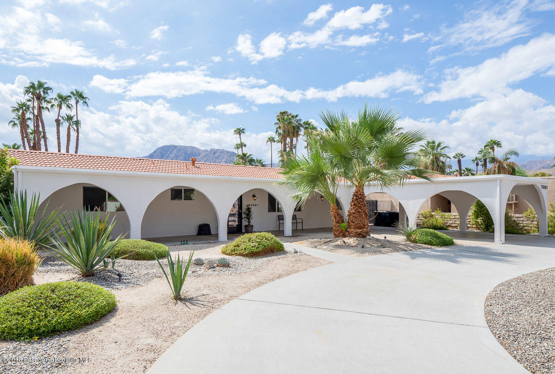 70081 Cobb Road Rancho Mirage, CA 92270 - Photo 1 of 17 a view of a white house with large windows and a table