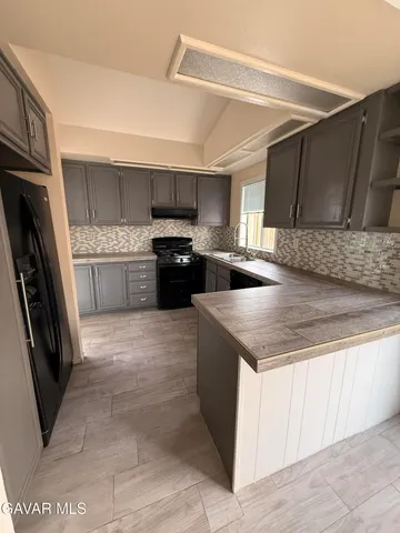 a kitchen with stainless steel appliances granite countertop a stove a sink and a refrigerator
