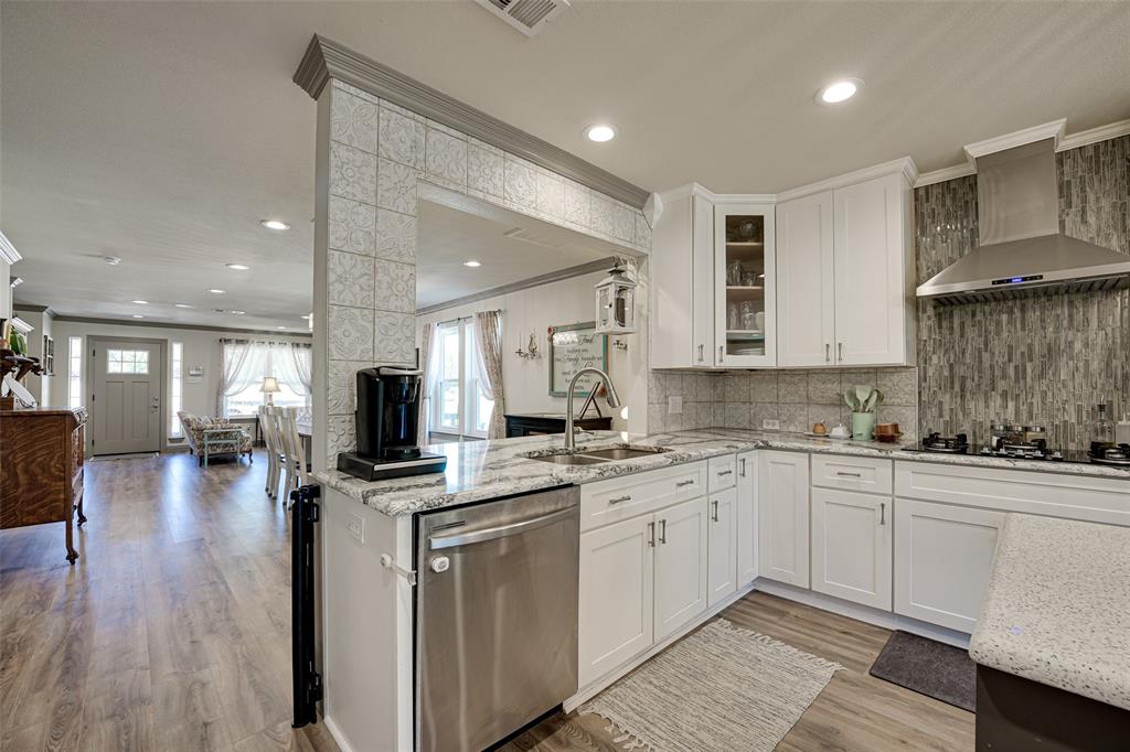 521 Bakers Branch Road Waxahachie, TX 75167 - Photo 16 of 37 Kitchen featuring white cabinetry, stainless steel appliances, speckled countertops, and a tiled backsplash
