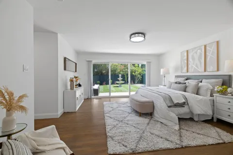 a spacious bedroom with a bed a table and chair