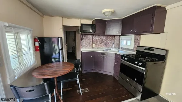 a kitchen with stainless steel appliances a table chairs and a refrigerator