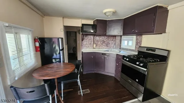 a kitchen with stainless steel appliances a table chairs and a refrigerator