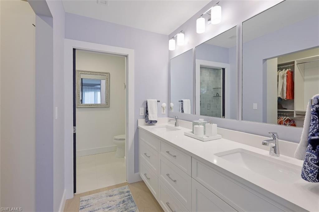 1060 6th Street South, Unit 1060 Naples, FL 34102 - Photo 12 of 31 a bathroom with double vanity sinks and a mirror
