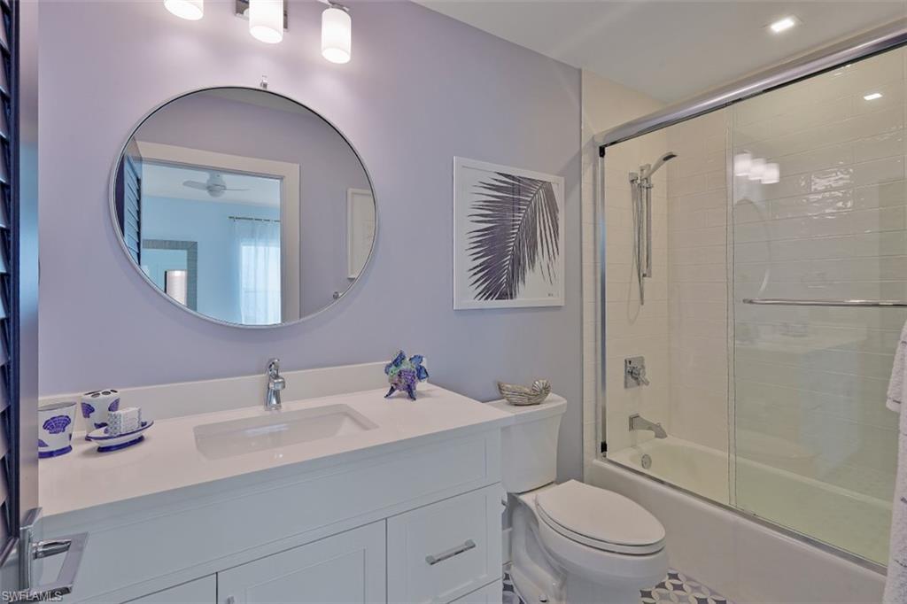 1060 6th Street South, Unit 1060 Naples, FL 34102 - Photo 17 of 31 a bathroom with a toilet a sink a mirror a bathtub and vanity