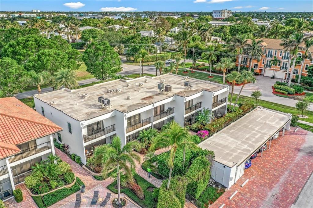 1060 6th Street South, Unit 1060 Naples, FL 34102 - Photo 24 of 31 an aerial view of a house with swimming pool and large trees
