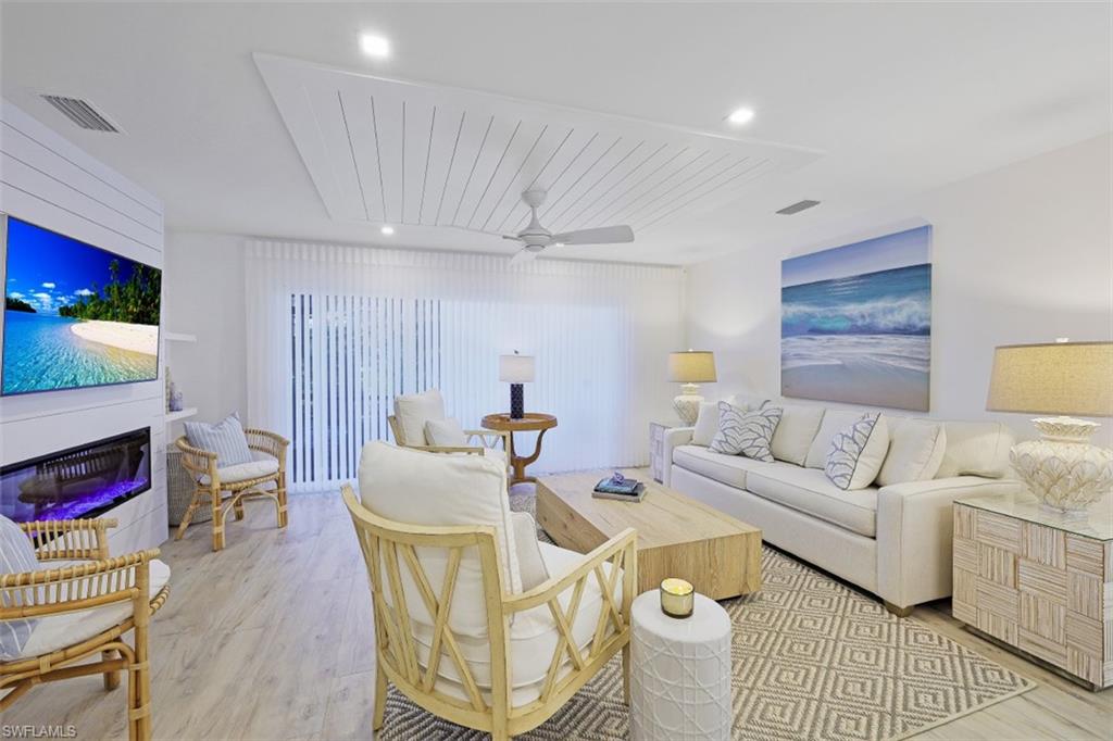 1060 6th Street South, Unit 1060 Naples, FL 34102 - Photo 4 of 31 a living room with furniture a flat screen tv and a table