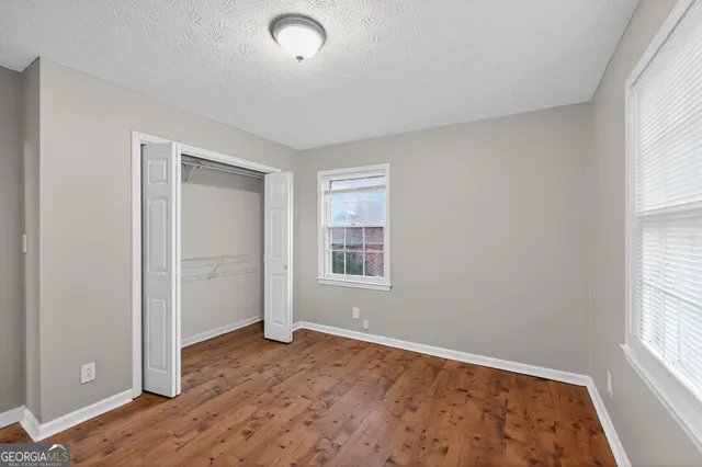 an empty room with windows and closet