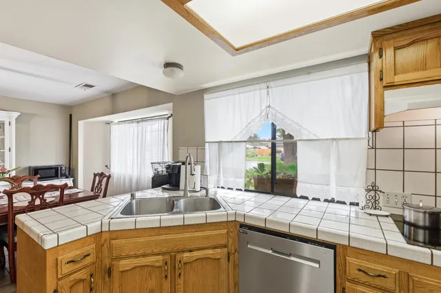 a room with stainless steel appliances kitchen island granite countertop furniture a sink and a window