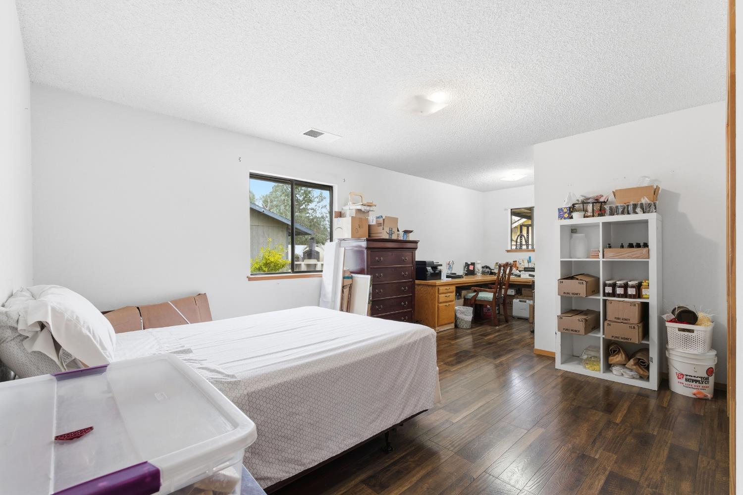 12126 Topper Road Madera, CA 93636 - Photo 15 of 40 a bedroom with a bed and wooden floor