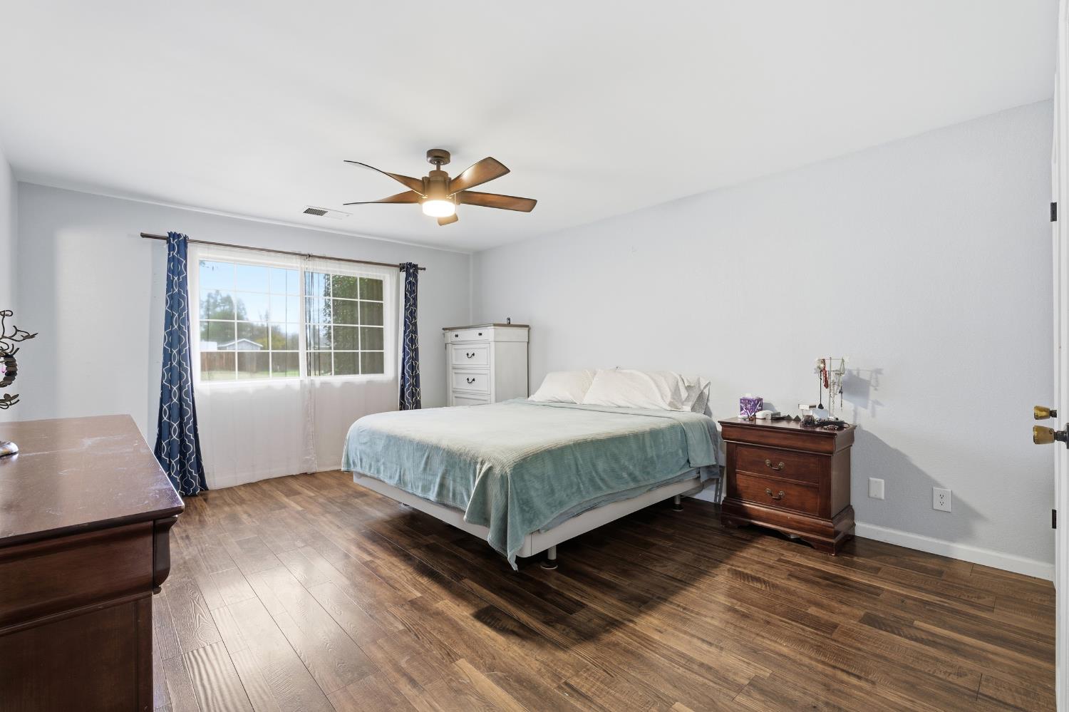 12126 Topper Road Madera, CA 93636 - Photo 20 of 40 a bedroom with a bed and wooden floor